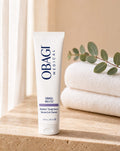 Obagi Nu-Cil BioStim Sérum Capilar de pie sobre repisa de travertino con toallas y eucalipto, vista frontal