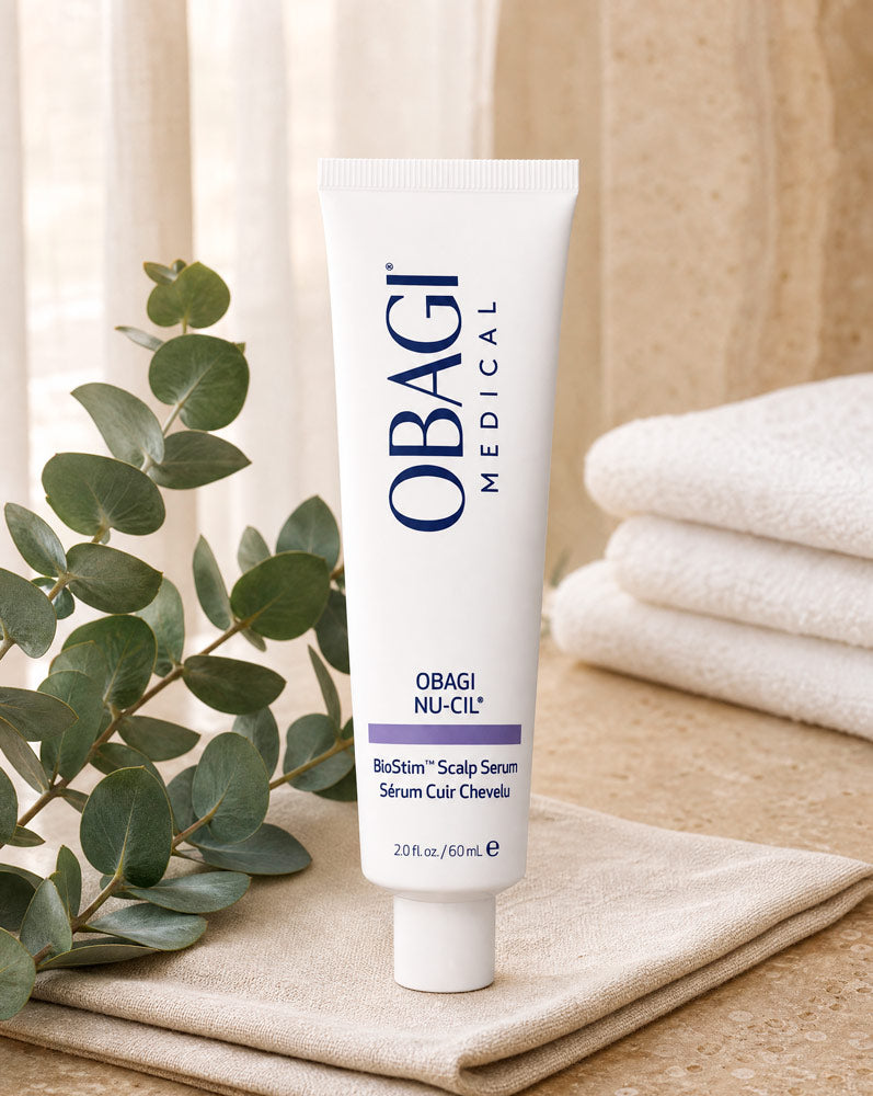 Obagi Nu-Cil BioStim Sérum Capilar de pie sobre servilleta de lino con eucalipto