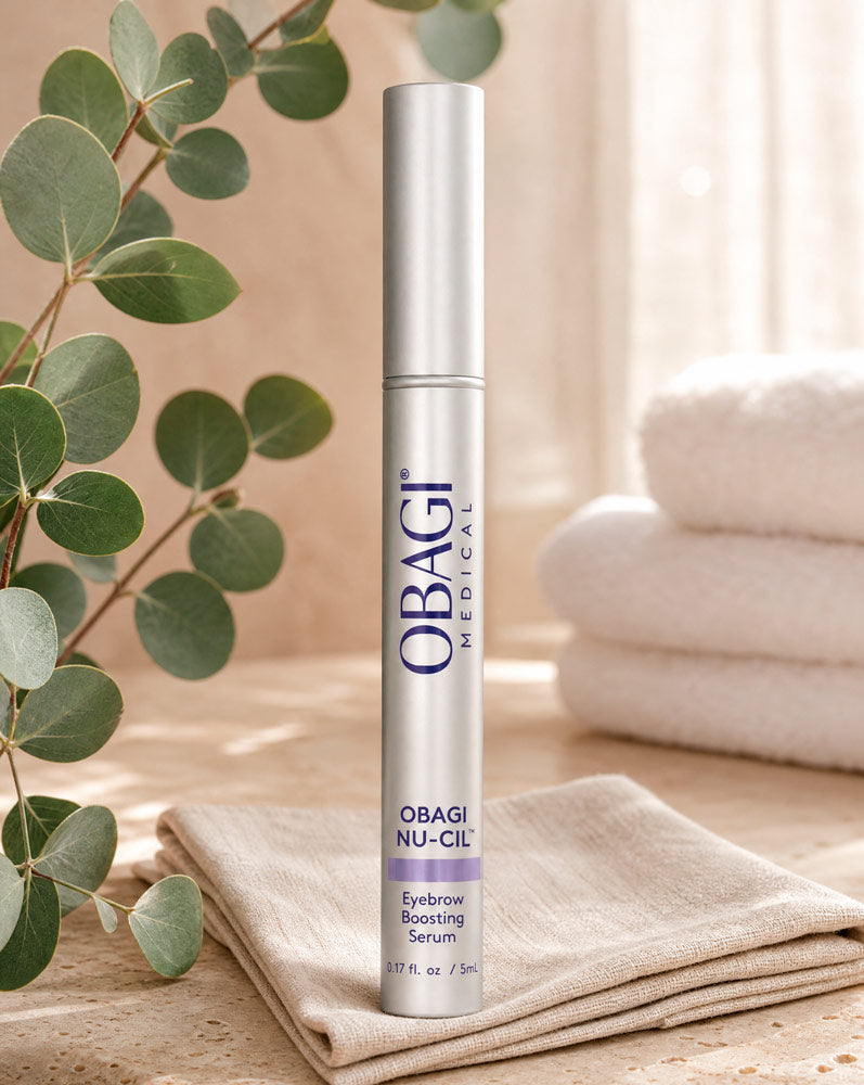 Obagi Nu-Cil Sérum Potenciador de Cejas de pie sobre servilleta de lino con eucalipto